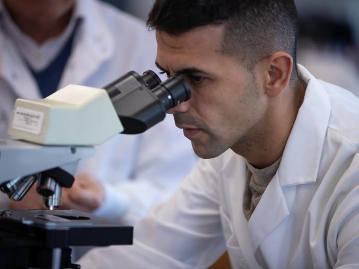 A student looks into microscope